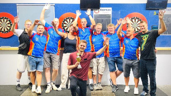 Mitglieder des Dartclub Gamsen 1996 jubeln, der Sieger kniet mit dem Pokal davor