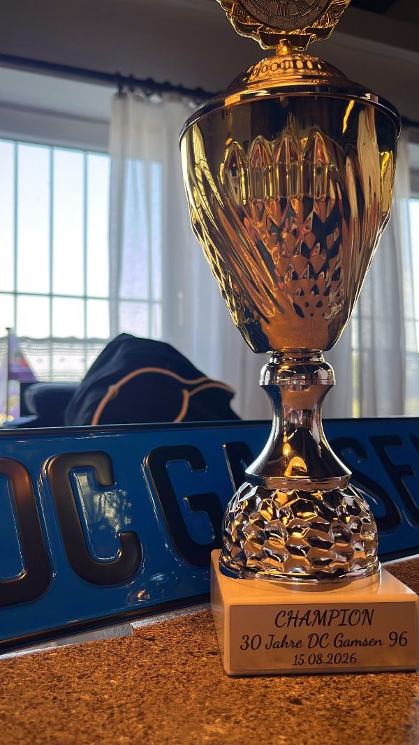 Goldener Siegerpokal vor dem Vereinsbanner