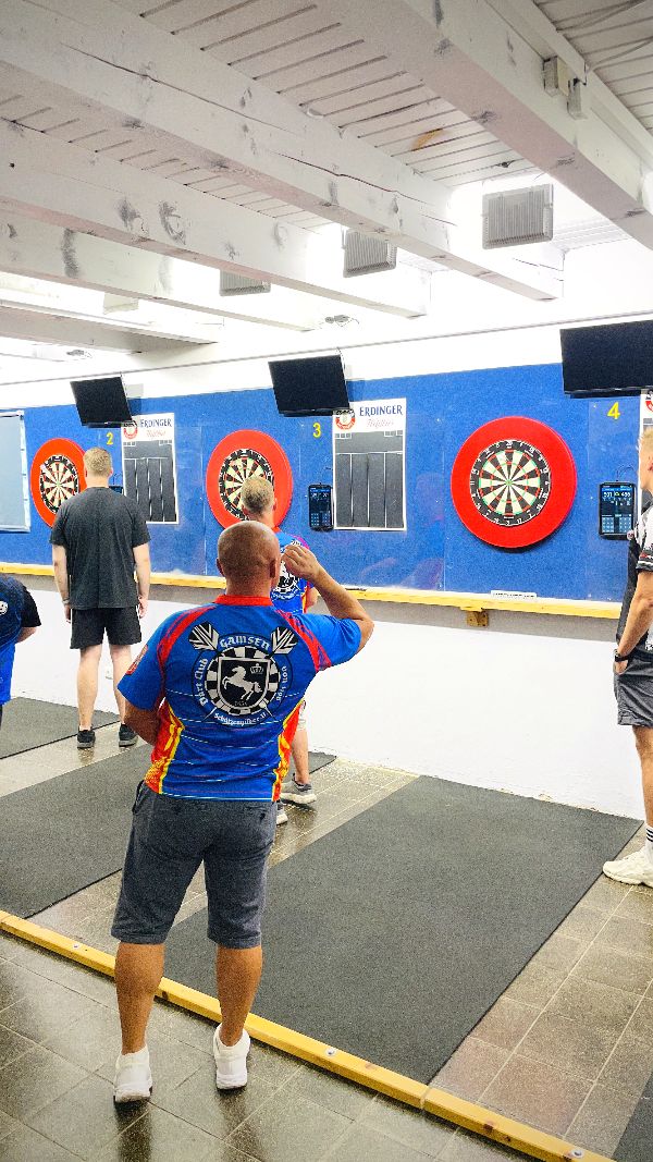 Spieler im Vereinstrikot am Dartboard
